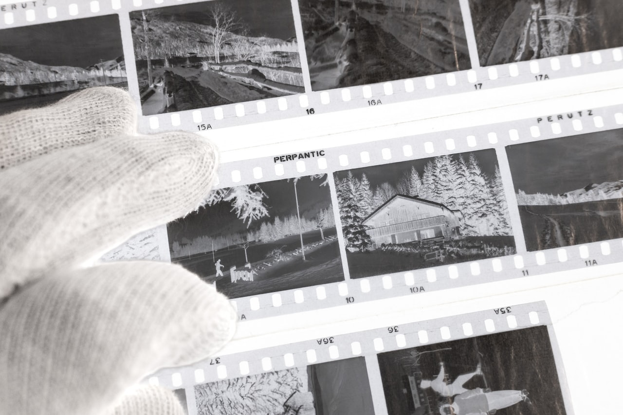 Ruka v rukaviciach, ktorá manipuluje so starými fotografiami